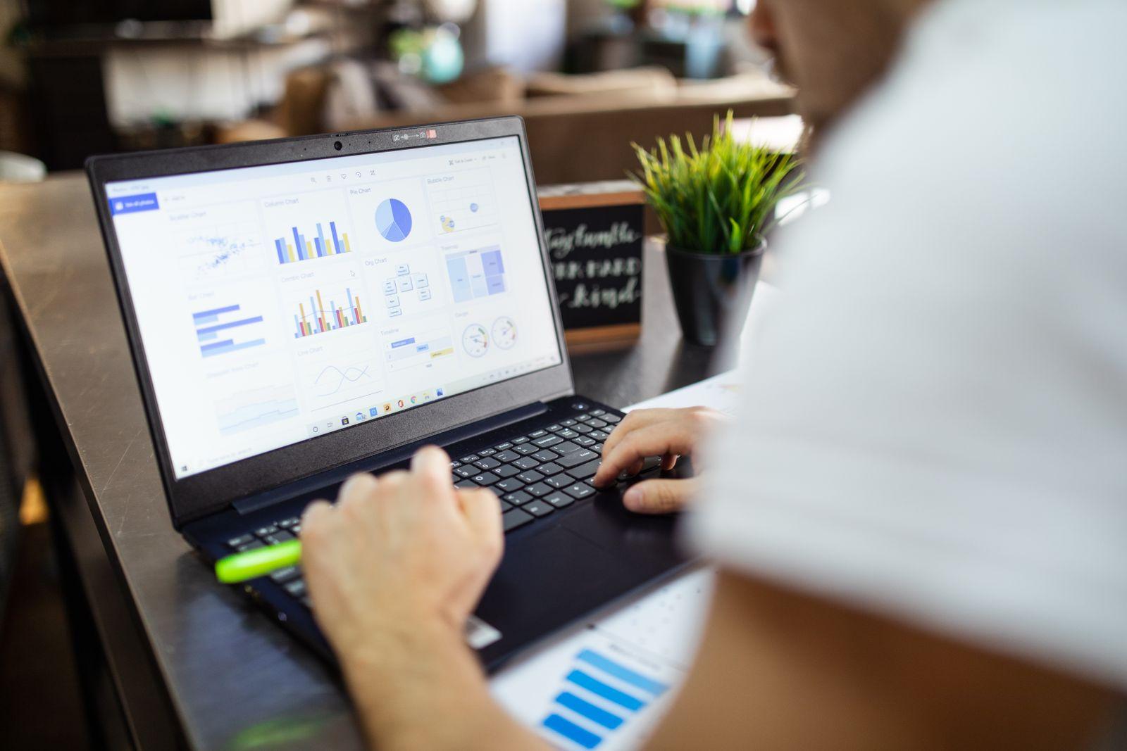 Modern ofis ortamında grafik ve tablolarla iş analizi yapan kişi